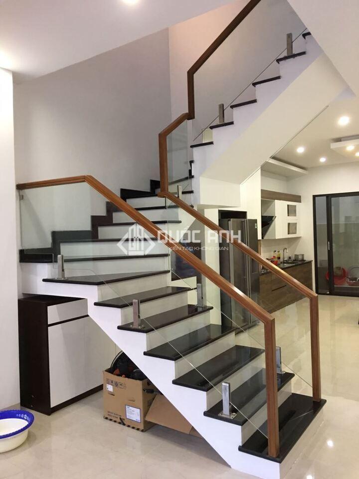 Cầu thang kính trụ lửng tay vịn gỗ.